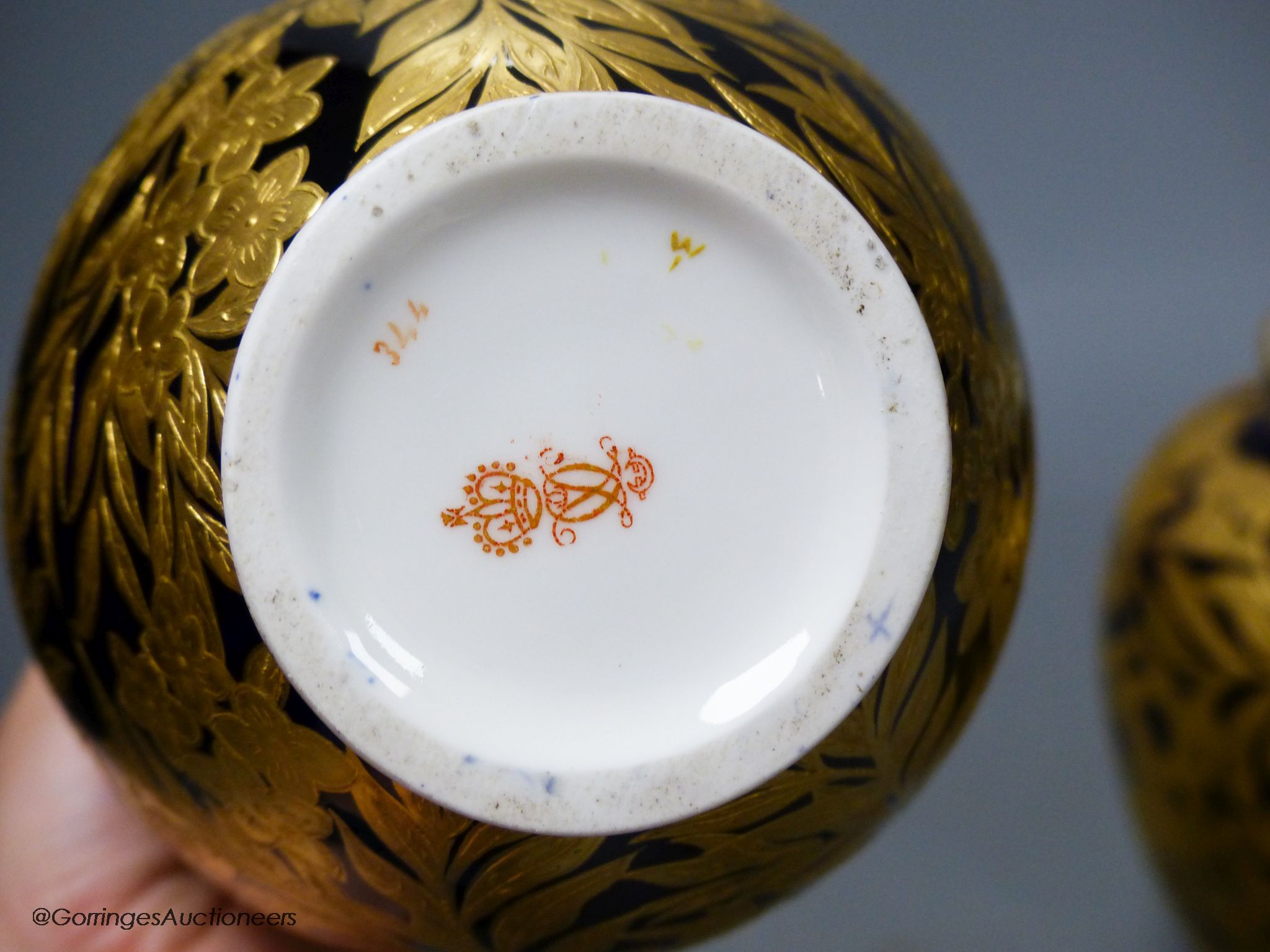 A pair of Crown Derby blue and gilt vases, both with restored lids, height 21cm